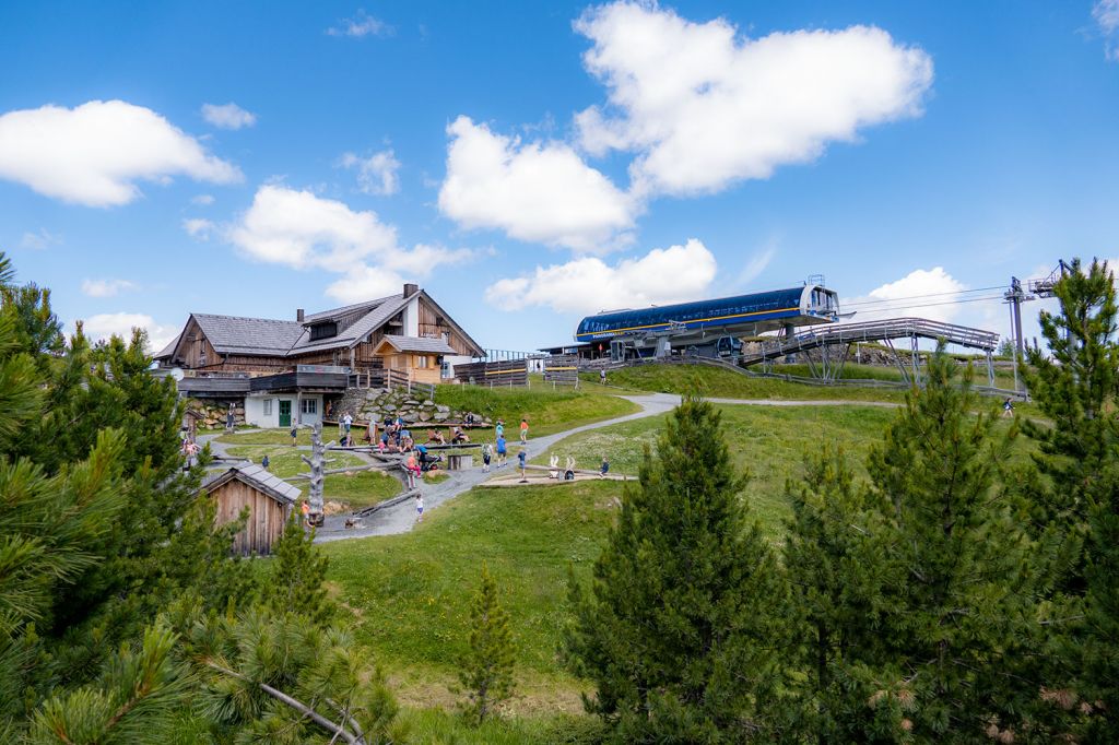 Nah beisammen - Blick vom Themenweg Nocky´s Almzeit auf die Bergstation der Panoramabahn sowie dem Bergrestaurant Almzeit. Davor liegt ein Spielplatz. - © alpintreff.de - Silke Schön