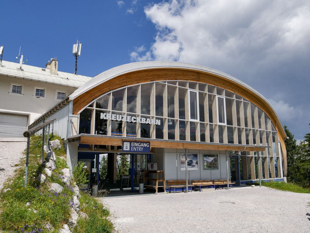 Mit der Kreuzeckbahn aufs Garmischer Kreuzeck - Die Kreuzeckbahn ist die älteste Bahn in Garmisch-Partenkirchen. Nein - natürlich nicht diese Version hier, denn die stammt aus dem Jahr 2002. Den Vorgänger allerdings gab es mit ein paar Umbauten seit dem Jahr 1926, in dem die Kreuzeckbahn als erste Seilschwebebahn in Bayern ihren Betrieb aufnahm. Die Kapazität von anfangs sogar nur 150 Personen in der Stunde reichte natürlich nie und so wurde nach zahlreichen Umbauten und den begrenzt möglichen Erweiterungen der Kapazität im Winter 2002 die heutige Anlage mit einer Förderleistung von 2.000 Personen pro Stunde in Betrieb genommen.
Die Bahn ist auch im Sommer extrem beliebt und führt auf etwa 1.600 Meter Seehöhe. Von dort geht es unter anderem auf einem Fahrweg weiter zur Hochalm, wo sich die nächste Seilbahn anschließt. - © alpintreff.de Mit der Kreuzeckbahn aufs Garmischer Kreuzeck - Die Kreuzeckbahn ist die älteste Bahn in Garmisch-Partenkirchen. Nein - natürlich nicht diese Version hier, denn die stammt aus dem Jahr 2002. Den Vorgänger allerdings gab es mit ein paar Umbauten seit dem Jahr 1926, in dem die Kreuzeckbahn als erste Seilschwebebahn in Bayern ihren Betrieb aufnahm. Die Kapazität von anfangs sogar nur 150 Personen in der Stunde reichte natürlich nie und so wurde nach zahlreichen Umbauten und den begrenzt möglichen Erweiterungen der Kapazität im Winter 2002 die heutige Anlage mit einer Förderleistung von 2.000 Personen pro Stunde in Betrieb genommen.
Die Bahn ist auch im Sommer extrem beliebt und führt auf etwa 1.600 Meter Seehöhe. Von dort geht es unter anderem auf einem Fahrweg weiter zur Hochalm, wo sich die nächste Seilbahn anschließt. - © alpintreff.de