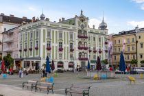 Reich an farbenprächtigem Blumenschmuck zeigt sich das Gmundener Rathaus am Rathausplatz. Unten befindet sich ein Cafe. • © alpintreff.de - Christian Schön