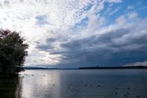 Chiemsee - Die letzten Gewitterwolken hingen immer noch drohend über der herrlichen Kulisse. Hier vom Parkplatz Chiemsee an der Autobahn • © alpintreff.de / christian Schön