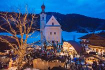 Der beschauliche Weihnachtsmarkt auf dem Goinger Kirchplatz wird umrahmt von der Kulisse des Wilden Kaisers. • © TVB Wilder Kaiser/Roland Defrancesco