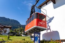 Die alte Hahnenkammbahn im Vordergrund, hinten an der Stütze die Gondeln der neuen Hahnenkammbahn.  • © alpintreff.de - Silke Schön