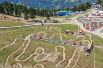 Im Vordergrund der Kidsbikepark mit seinen vier Trails und dem Förderband. Rechts hinten siehst Du die Erlebniswelt Goldwasser. Alles zusammen liegt in Nauders in Tirol. • © TVB Tiroler Oberland, Karl Folie