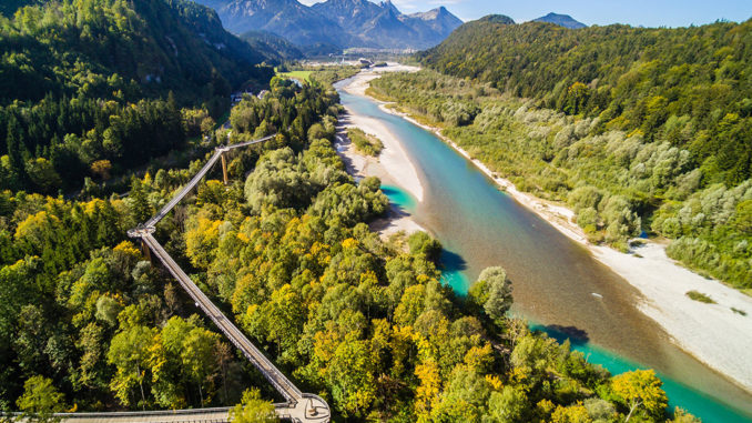 Aus der Vogelperspektive ist der Baumkronenweg im Walderlebnis Ziegelwies in Füssen/Allgäu gleich nochmal so eindrucksvoll und offenbart die Aussicht auf den Lech sowie den umliegenden Berg- und Auwald. // Foto: Füssen Tourismus und Marketing / Mathias Struck